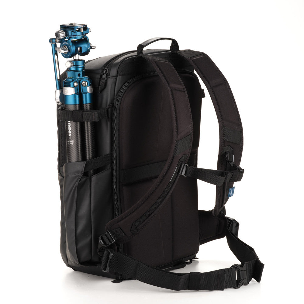 Black backpack with camera equipment on a white background