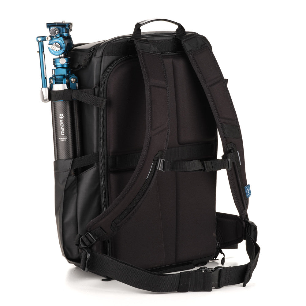 Black backpack with a camera tripod attached on a white background