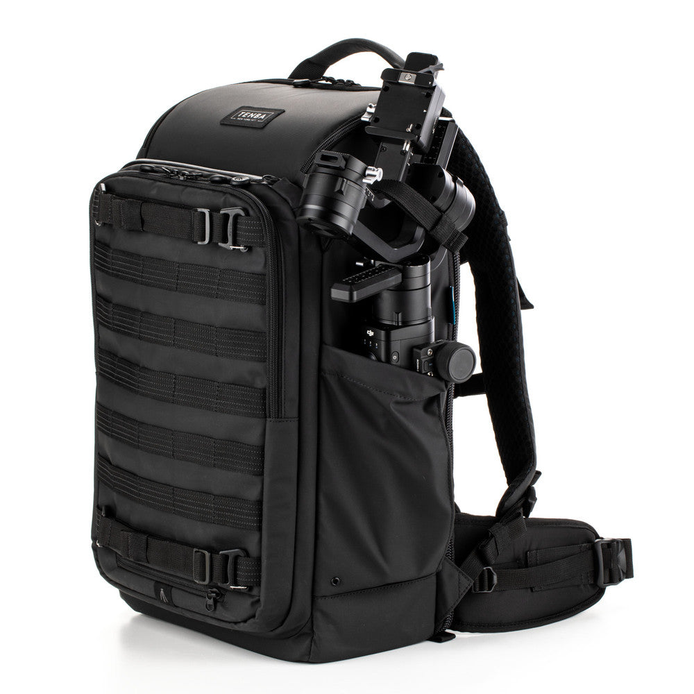 Black backpack with camera equipment on a white background
