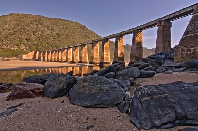Wide angle on a railway bridge showing rocks and old textured columns