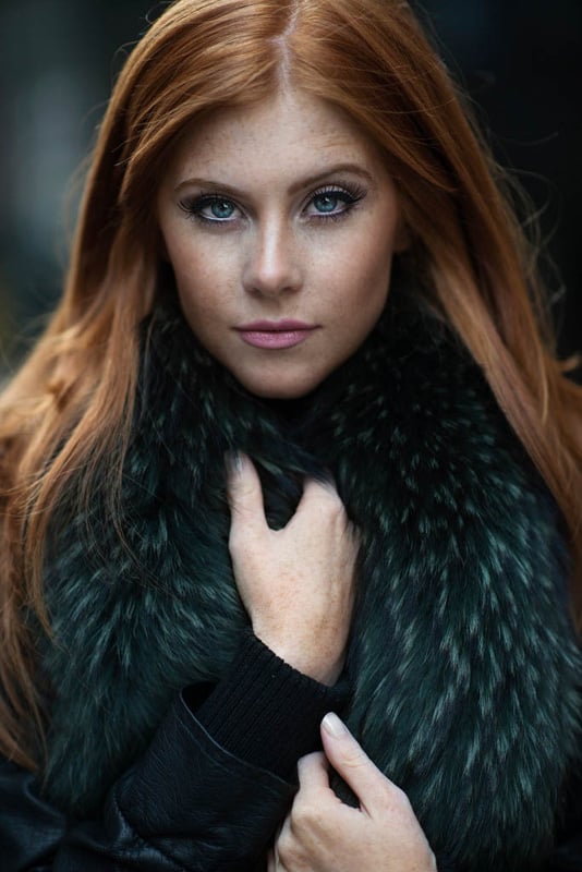 Red head with green eyes in fur coat