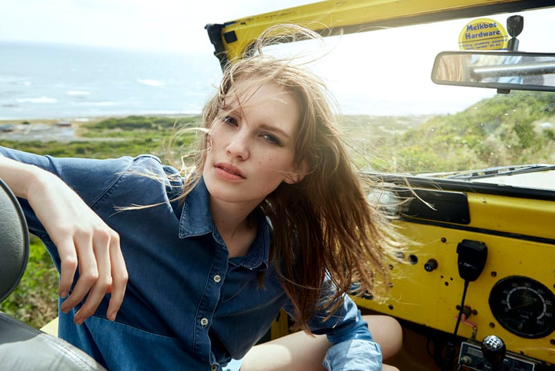 Photograph of model in a vehicle near the beach