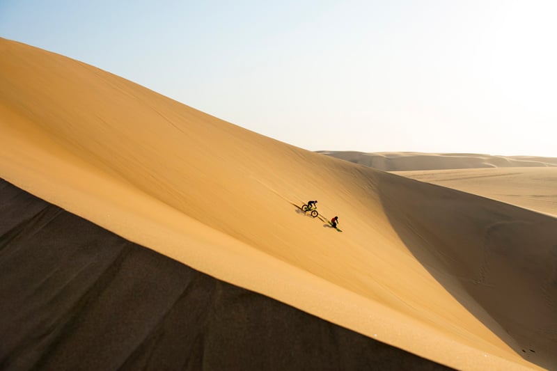 A photograph of two Red Bull Motorcross athletes riding in large dunes taken by Craig Kolesky
