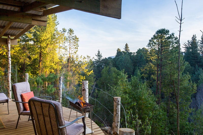 Photograph from the balcony of a house overlooking mountains and trees 