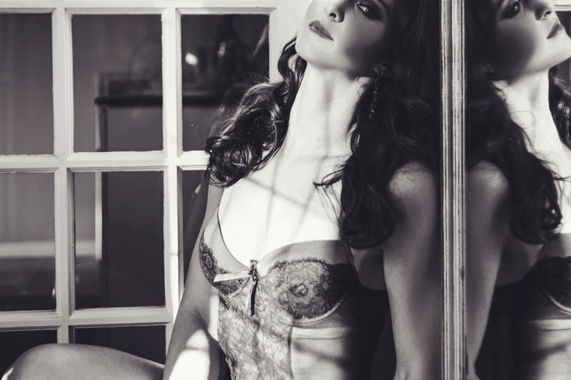 woman sitting with reflection in mirror boudoir photograph