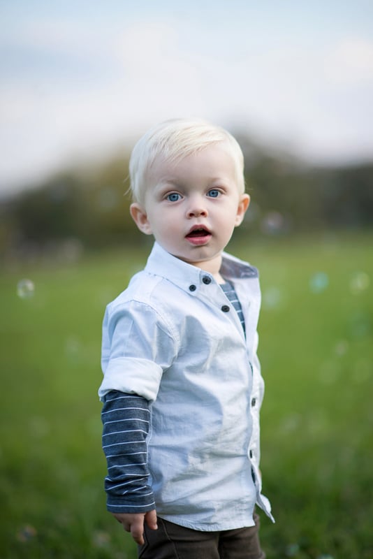 Toddler Photography: A little blonde haired boy with big blue eyes and bubbles in the background