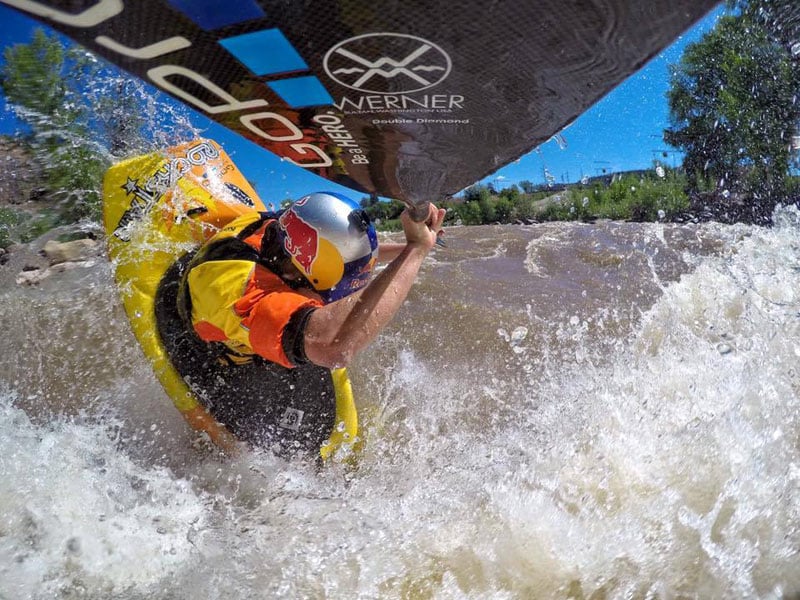 Dane Jackson surfing whitewater while taking a selfie using his GoPro