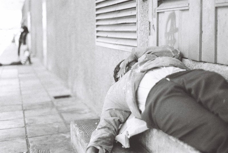 A homeless man sleeping on a set of stairs