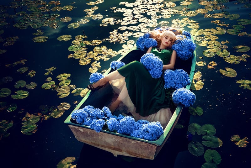 Dramatic Photograph of model on a pond in a boat Surrounded by Hydrangeas