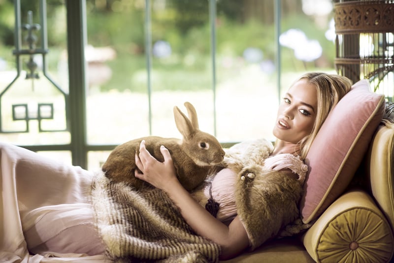 Female model on couch holding a rabbit