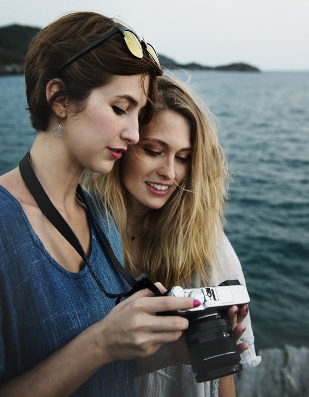 Two women looking on the back of a Fuji's LCD screen at photograph they took