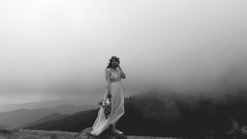 Photograph of bride with mountains in the background by Zelle Duda