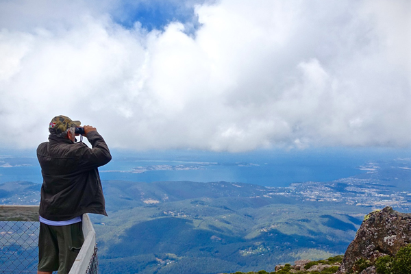 Looking at a view with binoculars Man looking for binoculars at landscape