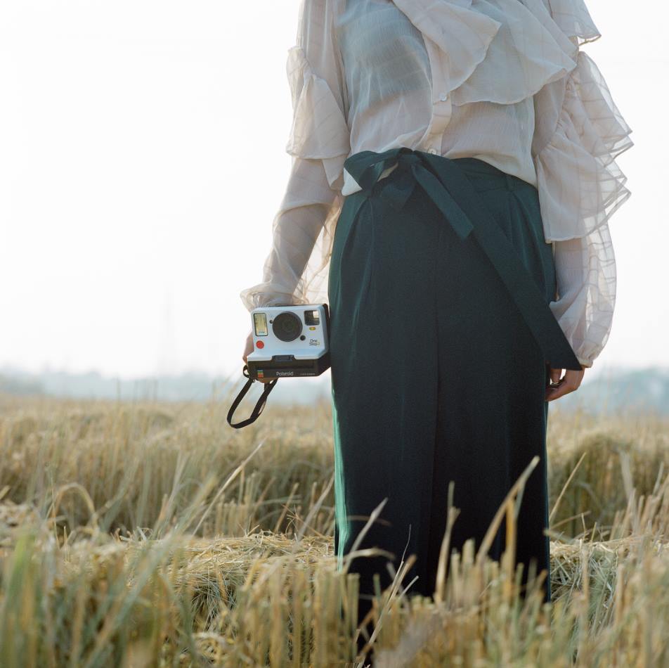 Polaroid original camera with girl photoshoot in field Polaroid original camera with girl photoshoot in field