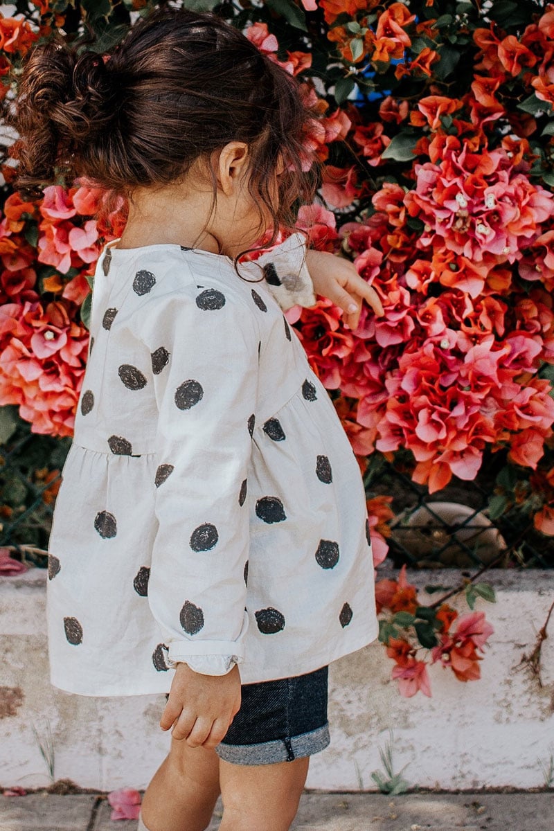 Girl outside admiring the flowers. Image by Vanessa Serpas.