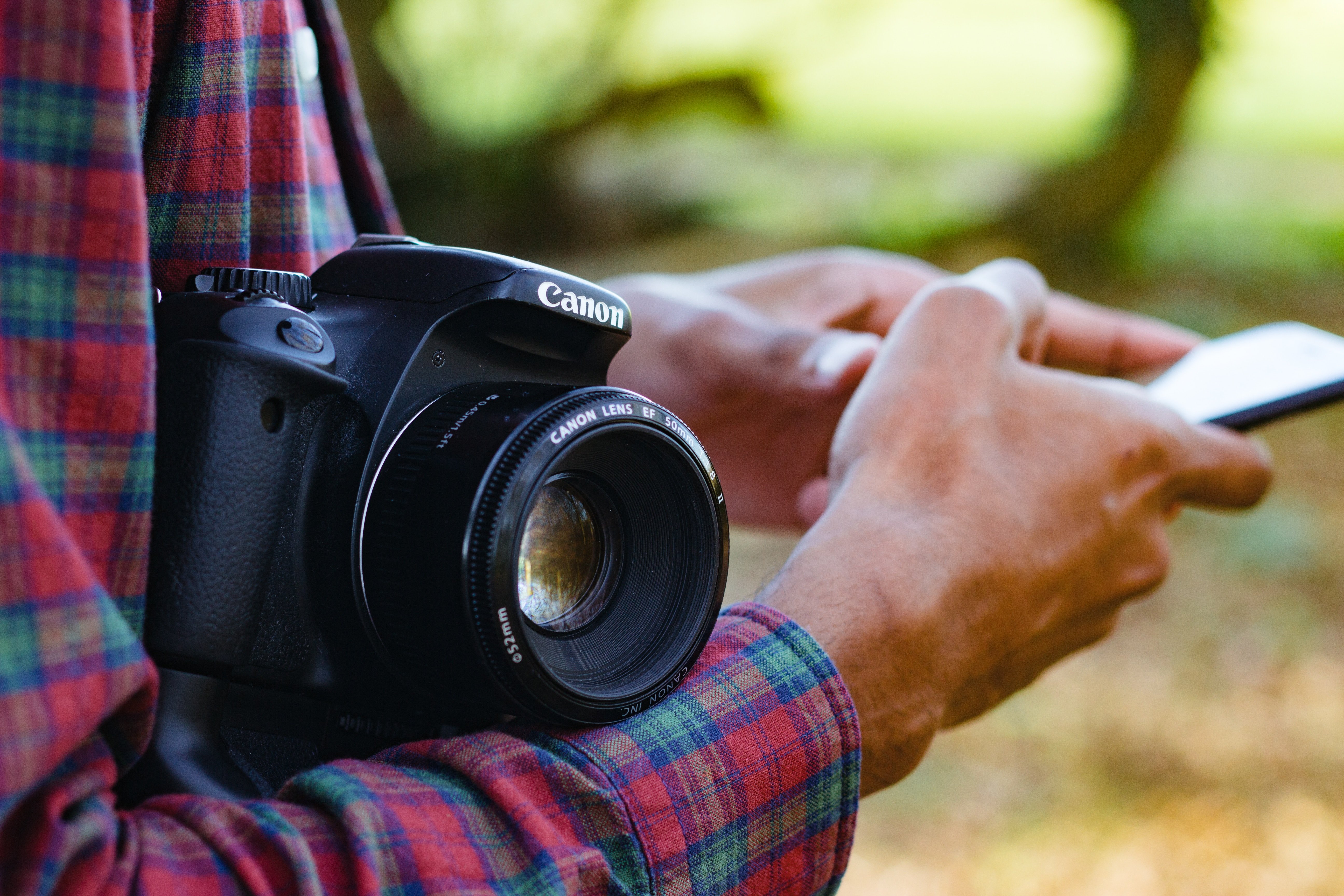 Man holding a camera and a mobile phone Man holding a camera and a mobile phone