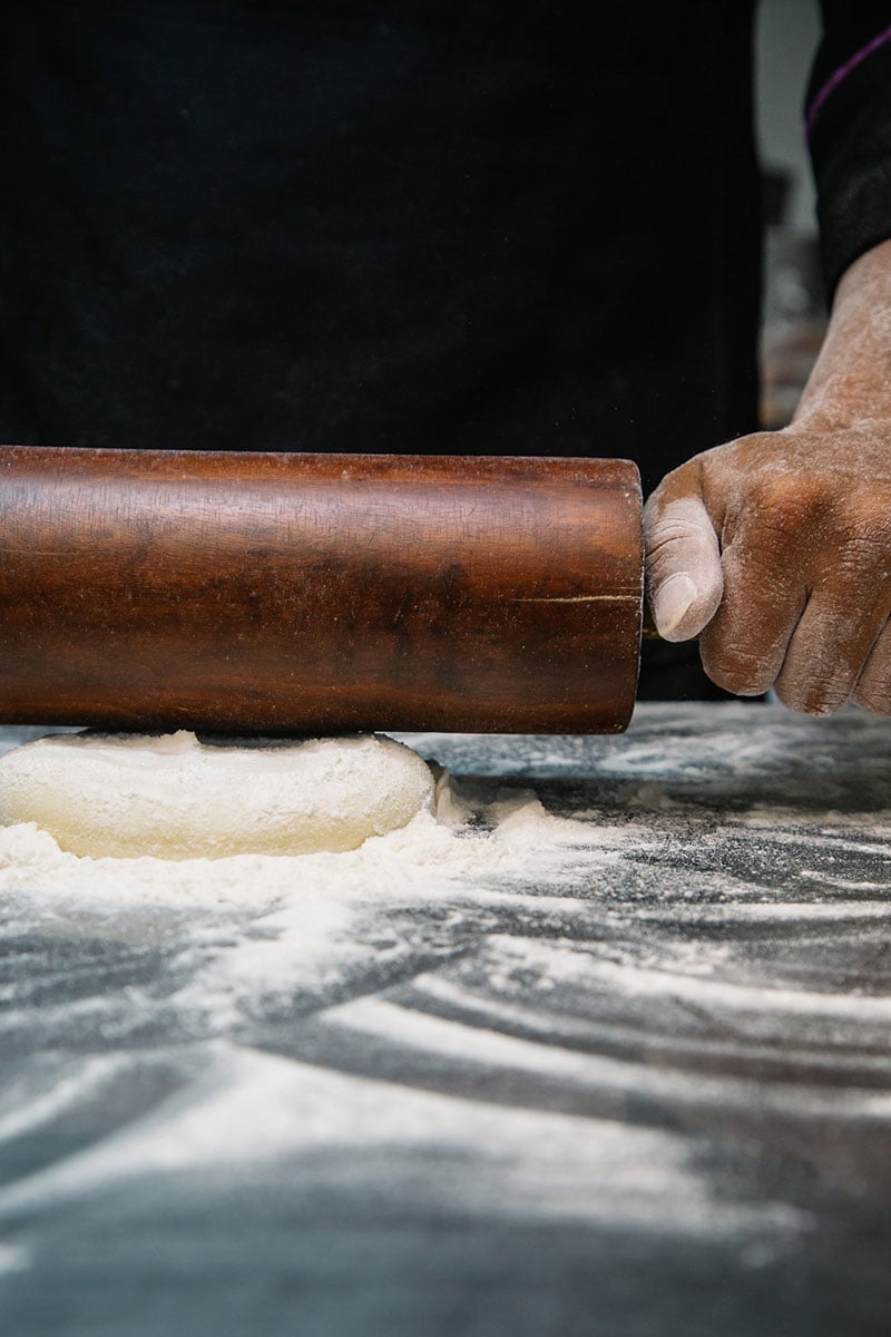 Food photograph of a man rolling out dough