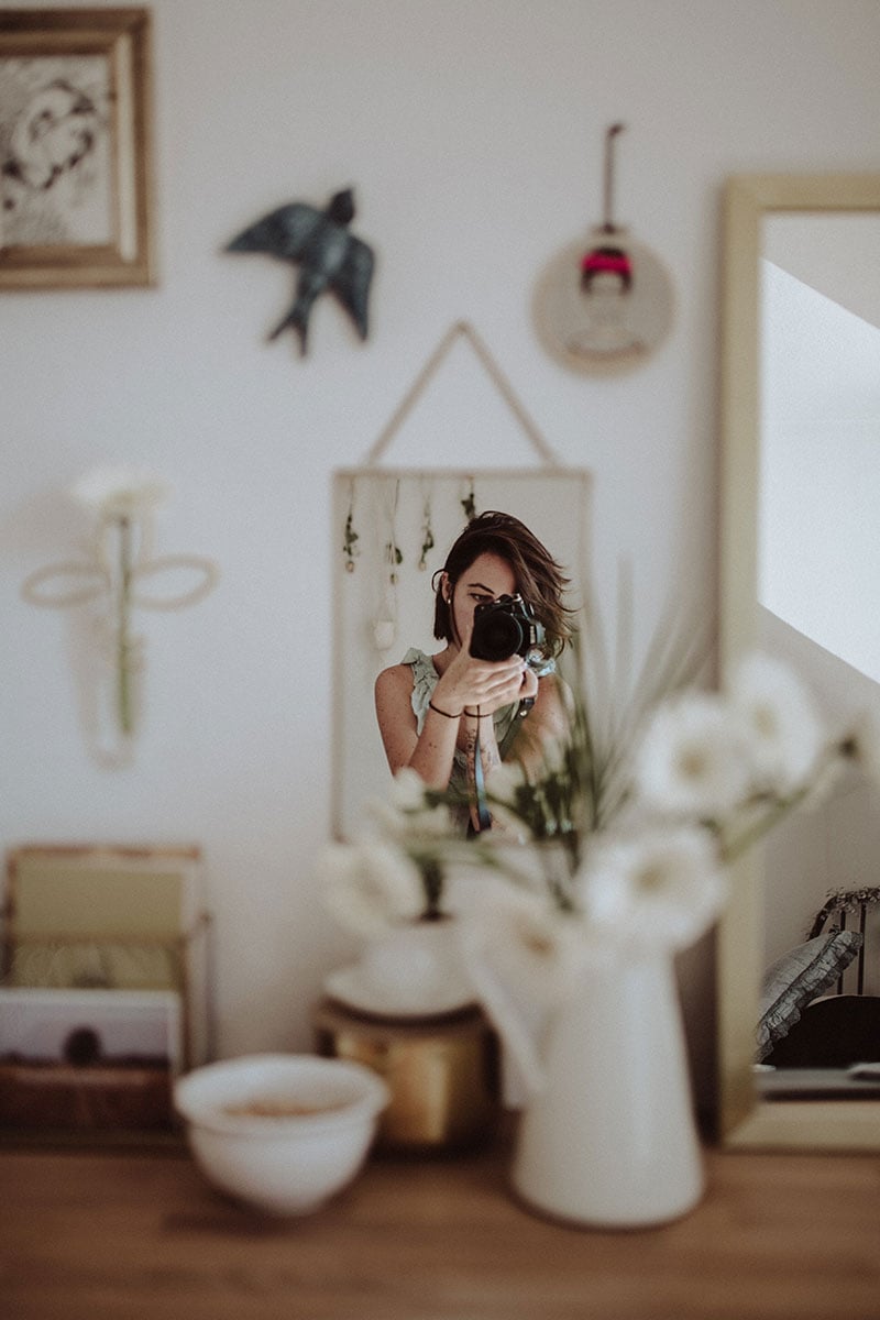 A woman taking a self-portrait in a mirror