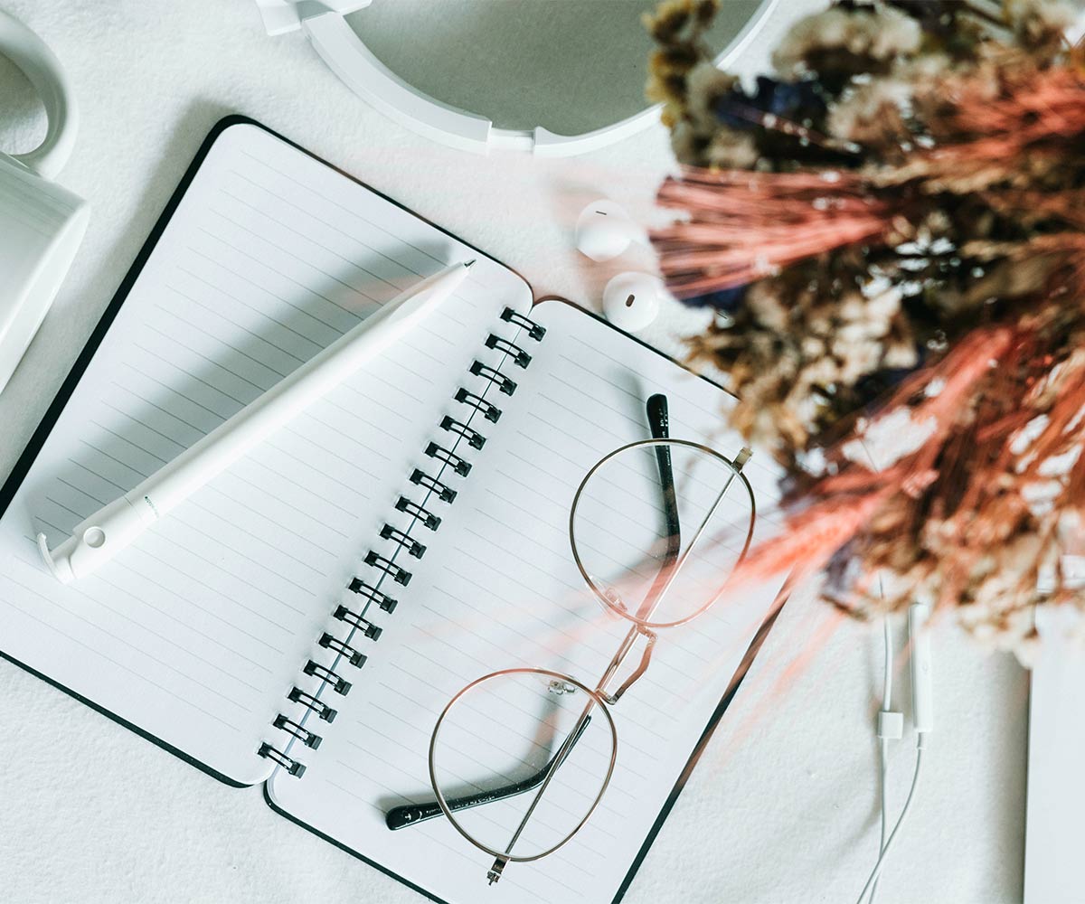 Notebook and glasses flatlay