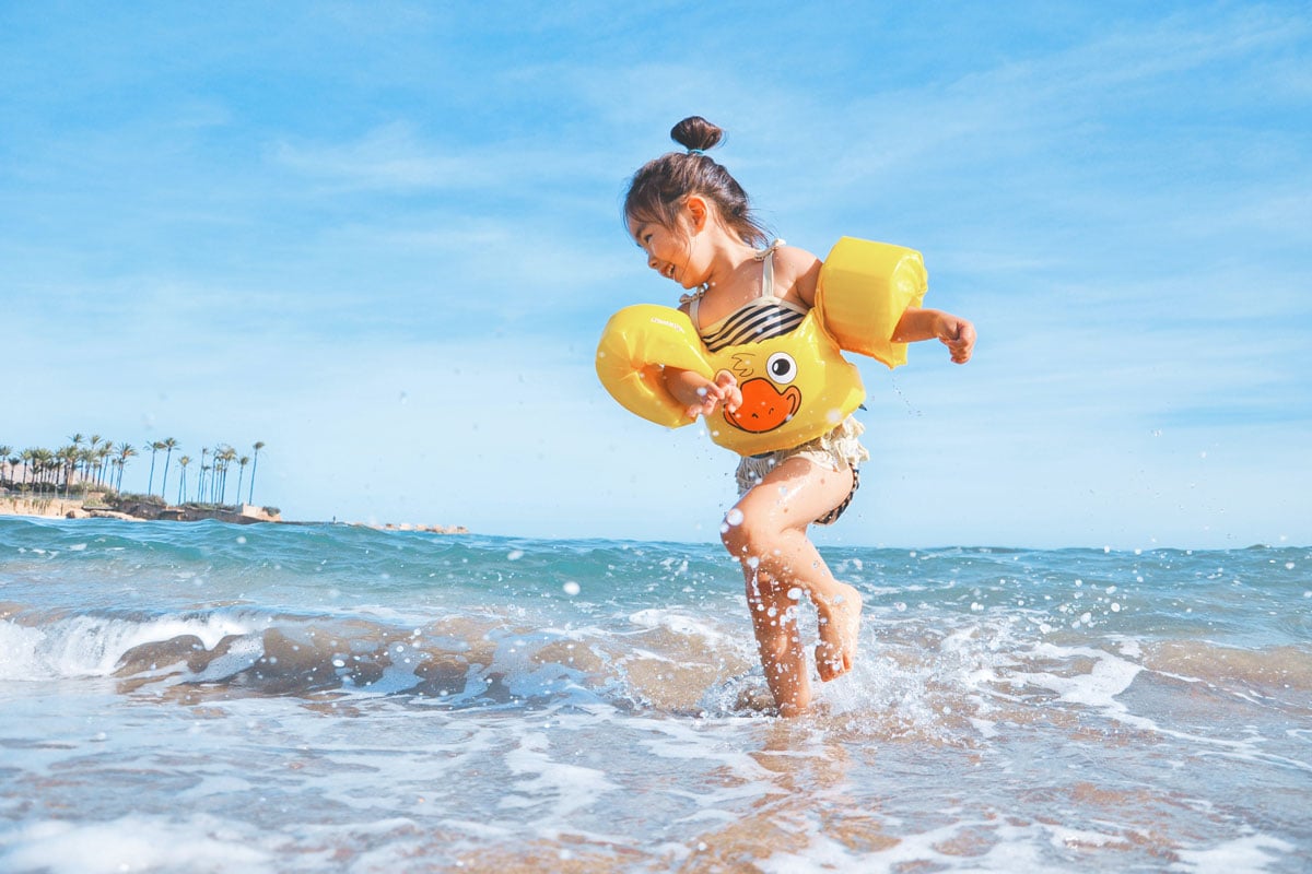 Summer holiday with kids Little girl having fun on the beach