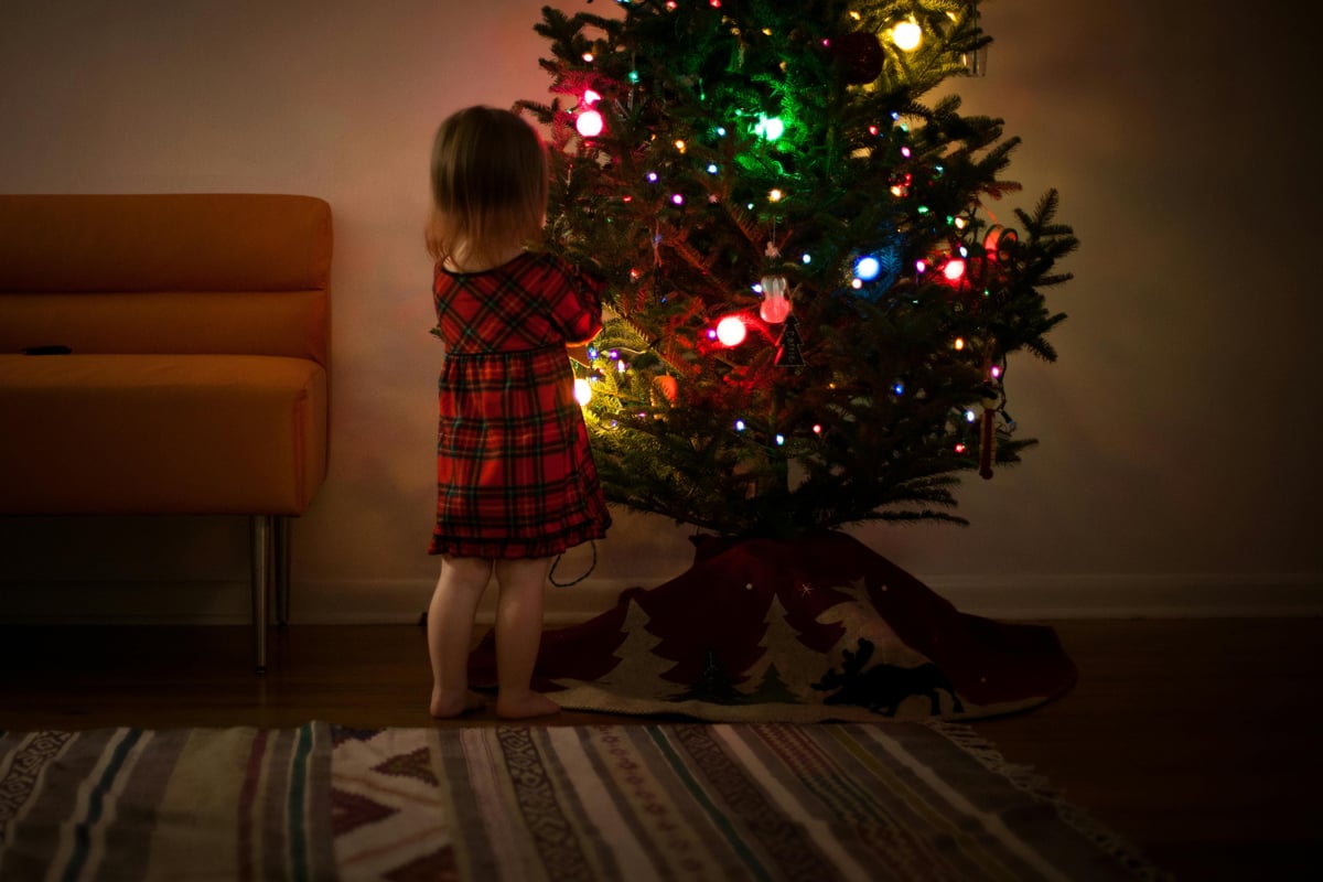 Festive lights photography Beautiful Christmas tree being decorated by a little girl