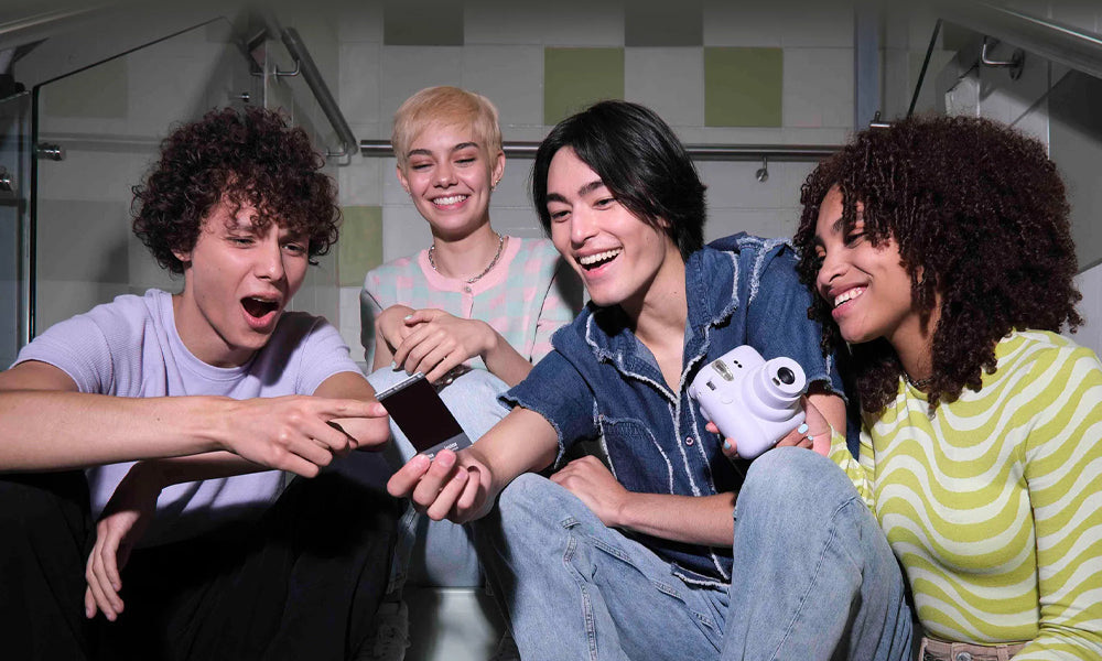A group of friends using the Instax Mini 12, looking at the photo that printed out.
