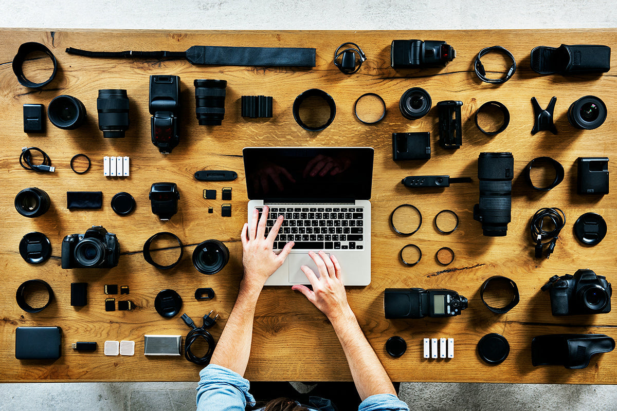Guy working with camera gear around his computer.