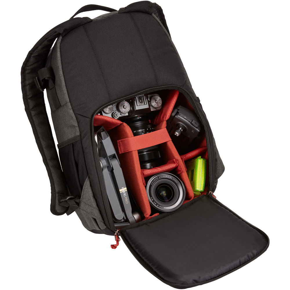 Black backpack with camera equipment inside on a white background