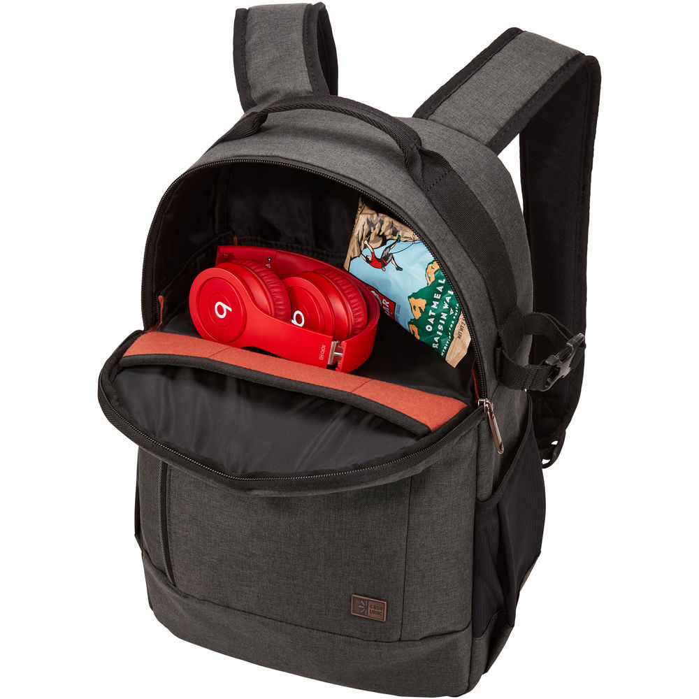 Gray backpack with open front compartment containing red headphones and a book on a white background