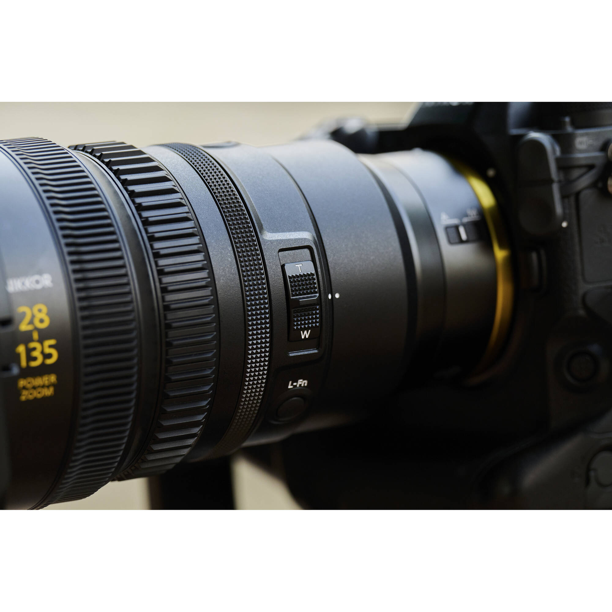Close-up of a camera lens with focus and zoom controls on a blurred background