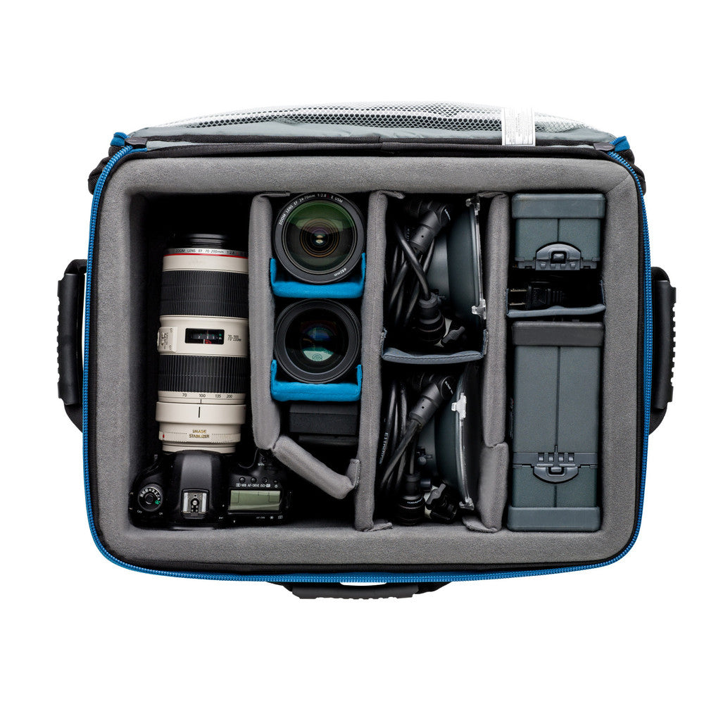 Camera bag with compartments containing camera equipment on a white background