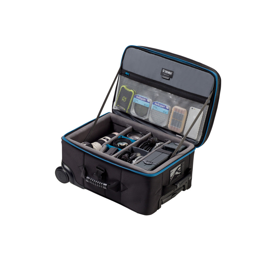 Open travel suitcase with compartments and items on a white background