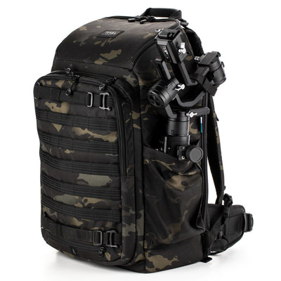 Camouflage backpack with camera equipment on a white background