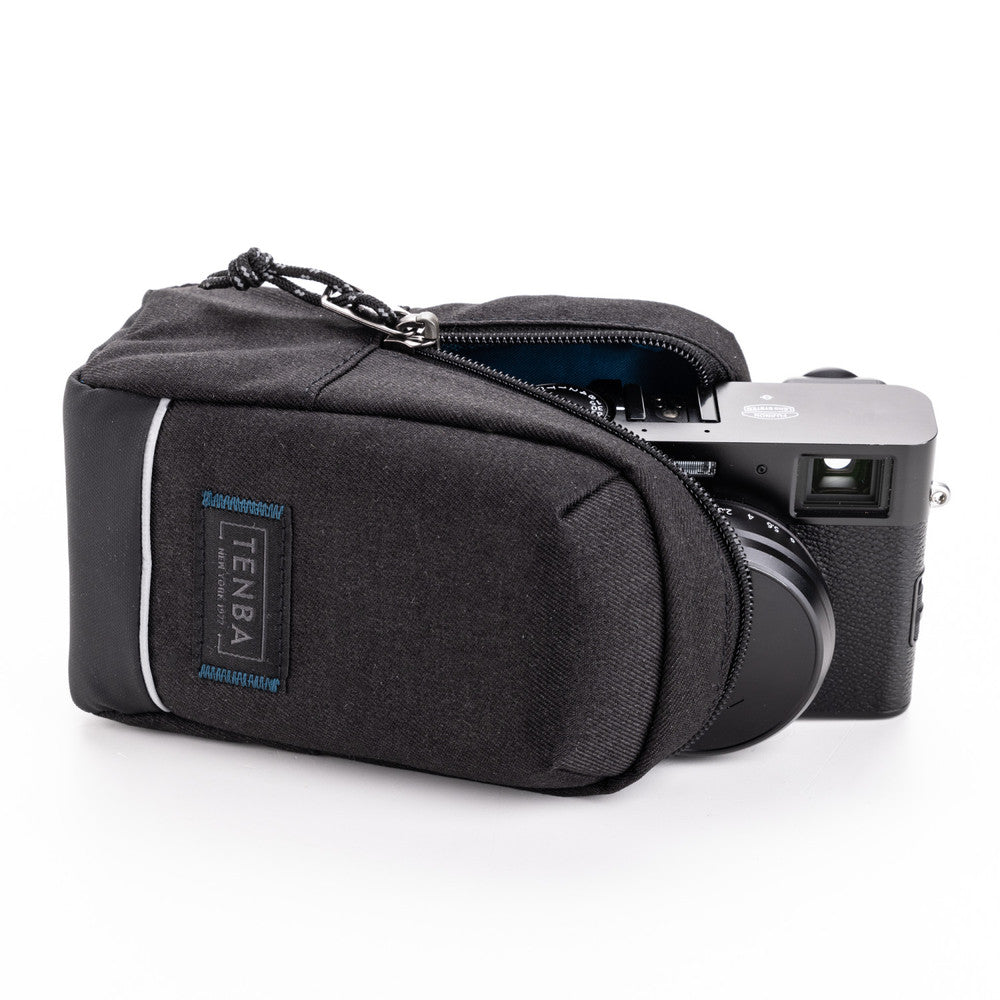 Black camera case with a camera inside on a white background, featuring the Tenba brand.