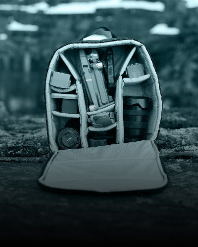 Camera backpack with camera equipment inside on a natural background
