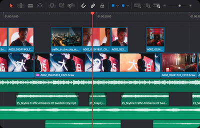 A screenshot of a video editing timeline interface with multiple video clips, audio tracks, a red play head, and a dark grey workspace.
