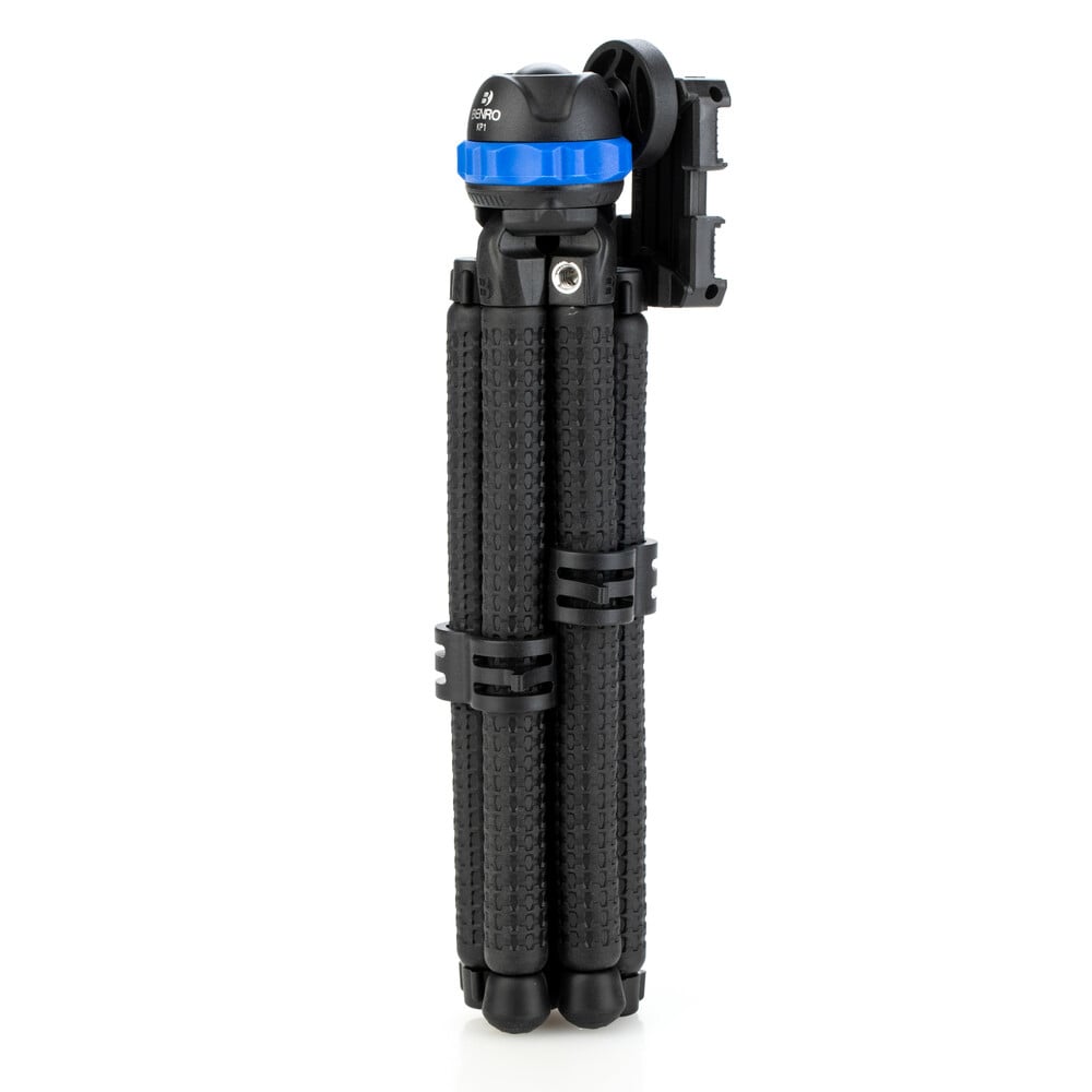 Black camera tripod with blue quick release plate on a white background