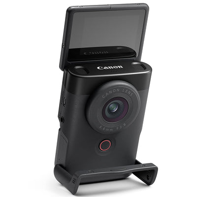 Canon PowerShot V10 Vlog Camera in black, compact rectangular body with wide-angle lens, tilting flip-up screen, and built-in stand.