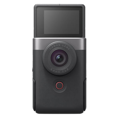 Canon PowerShot V10 vlog camera kit in silver — compact rectangular camera with wide-angle lens, flip-up screen, and integrated mini tripod stand.