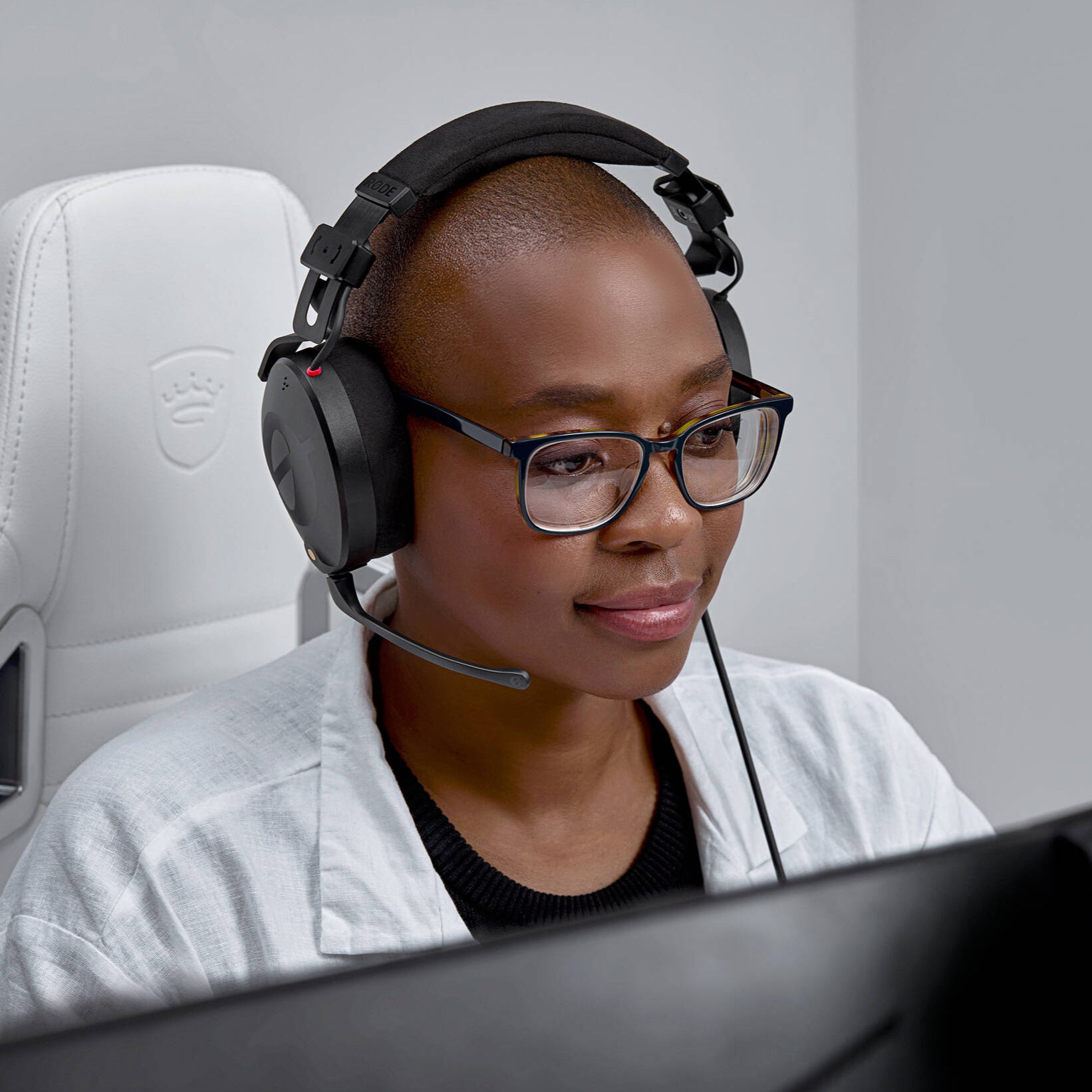 Black over-ear professional headset with adjustable boom microphone, detachable straight cable, and closed-back design.