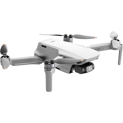 DJI Mini 4 K Fly More Combo — foldable camera drone with controller, three batteries, charging hub, shoulder bag, spare props, and accessories laid out.