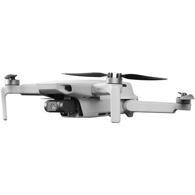 DJI Mini 4 K Fly More Combo — foldable camera drone with controller, three batteries, charging hub, shoulder bag, spare props, and accessories laid out.