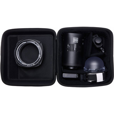 Black camera lens and accessories in a travel case on a white background