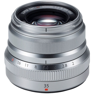 Silver camera lens with focus and aperture controls on a white background
