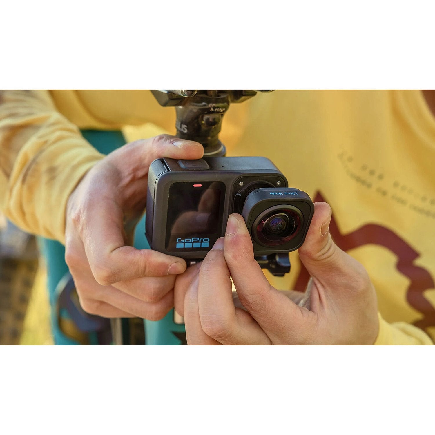 Person holding a GoPro camera with a blurred background