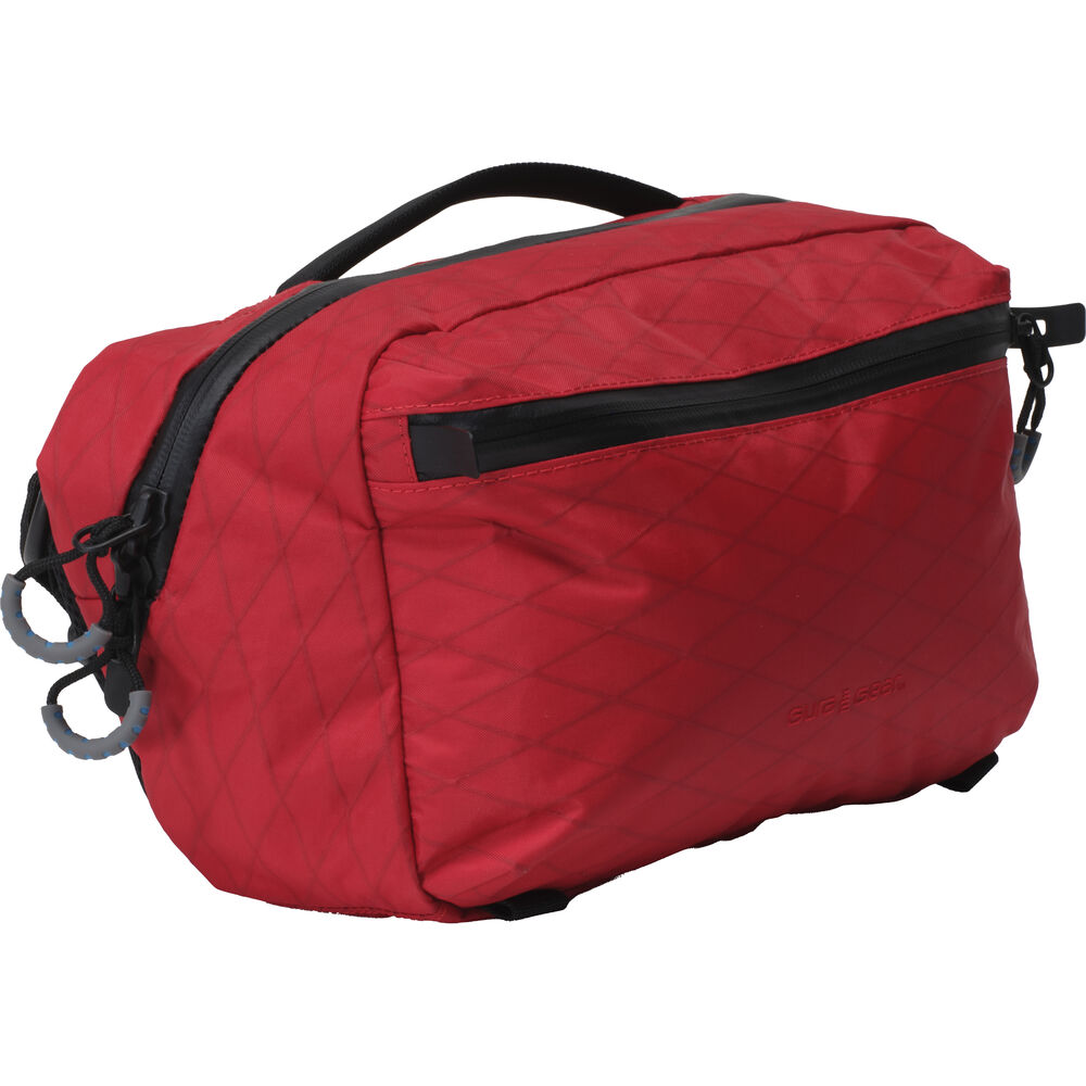 Red toiletry bag with black zippers on a white background
