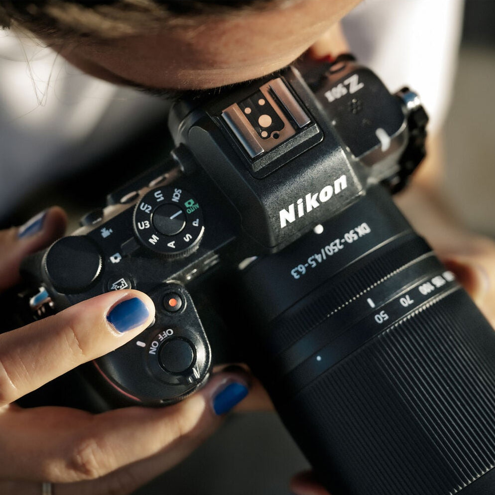 Nikon Z50 II mirrorless camera kit in black featuring two NIKKOR Z lenses (16–50 mm and 50–250 mm), with 3.2″ tilting touchscreen, built-in electronic viewfinder, and ergonomic textured grip.