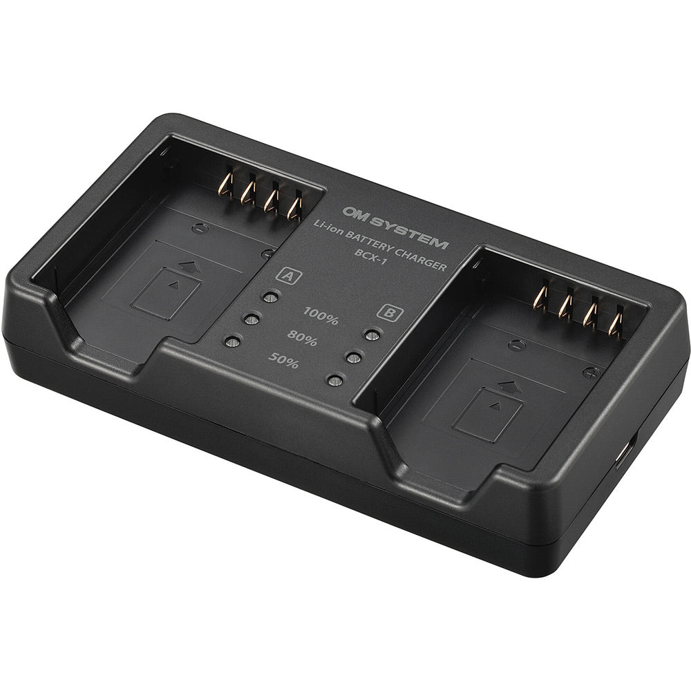 Olympus BCX-1 battery charger for BLX-1 rechargeable batteries, charges two batteries simultaneously in 150 minutes, USB-C powered with power delivery compatibility.
