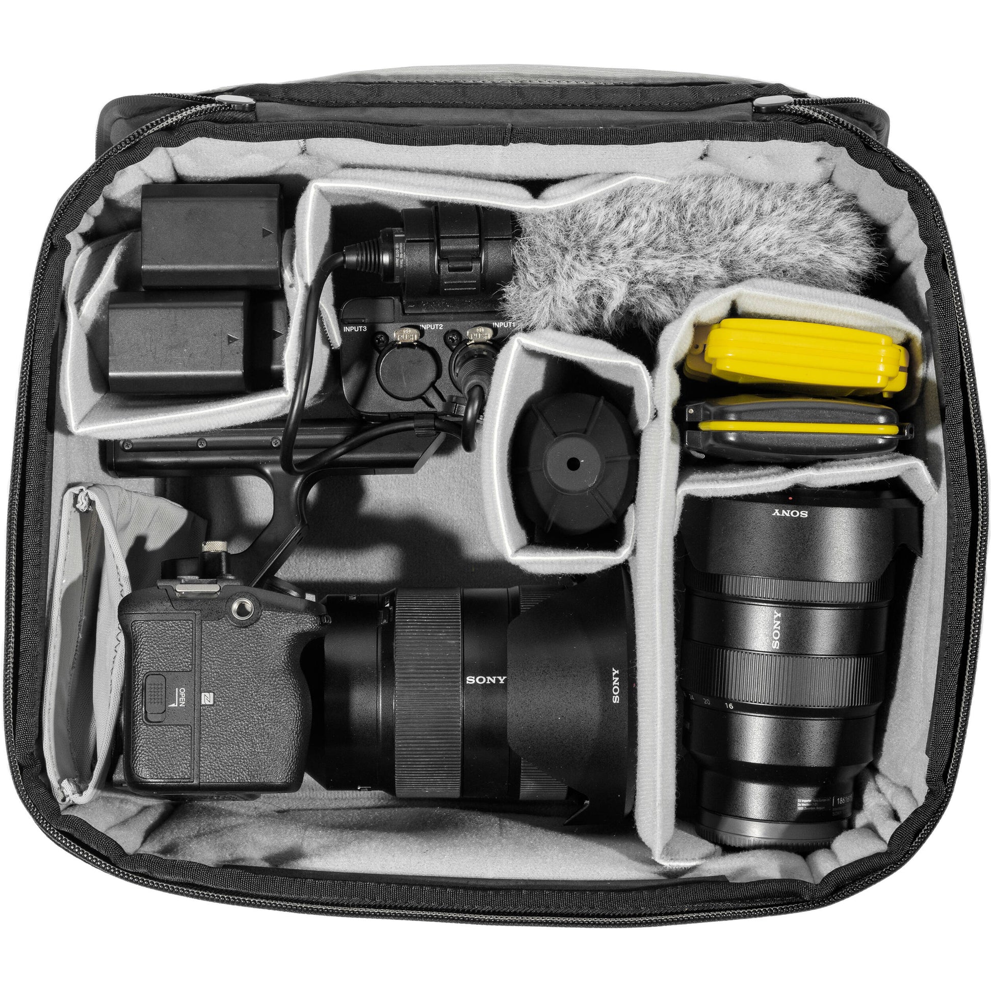 Black handheld Peak Design Camera Cube V2 with adjustable dividers, zipper closure, and durable nylon exterior, perfect for carrying camera gear safely.
