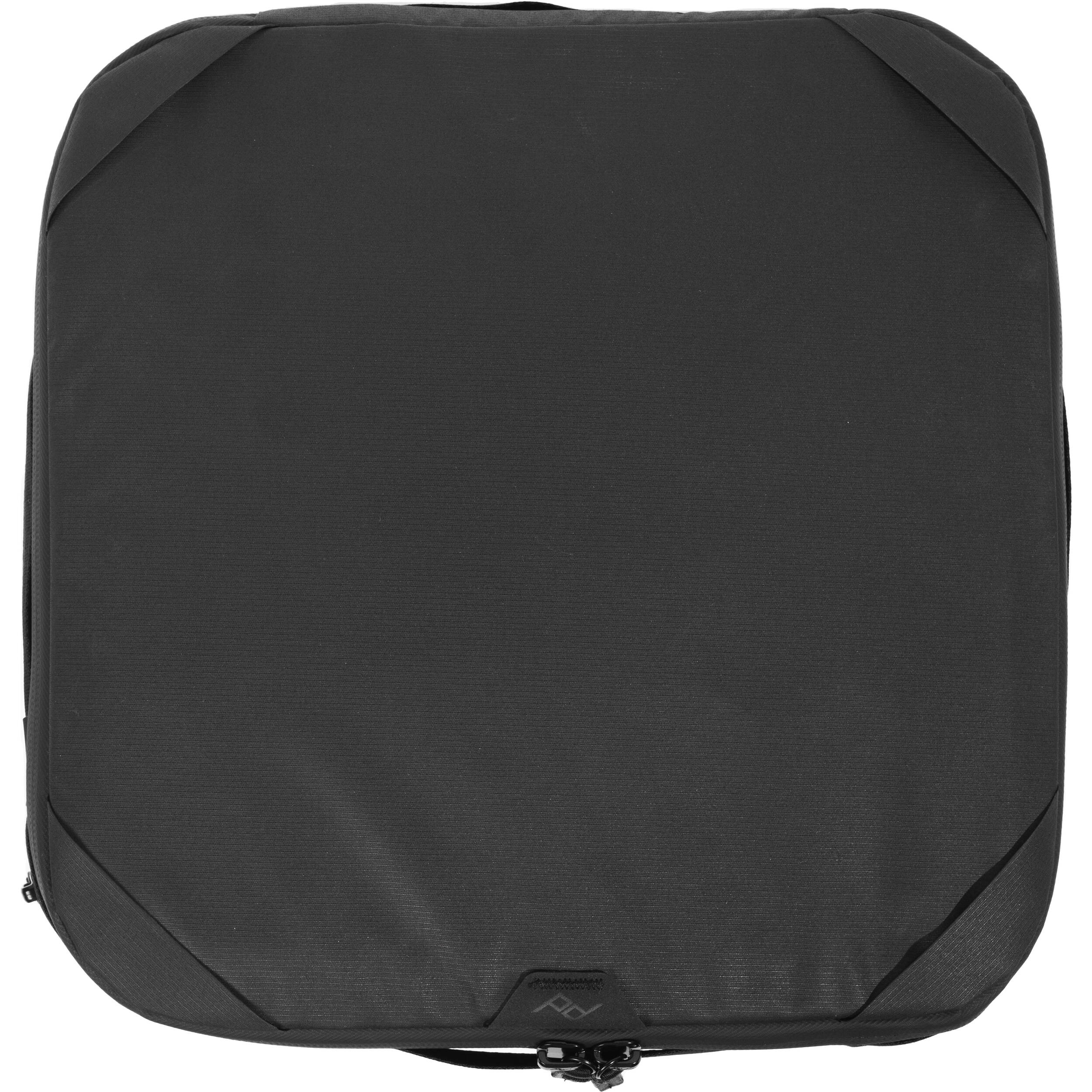 Black handheld Peak Design Camera Cube V2 with adjustable dividers, zipper closure, and durable nylon exterior, perfect for carrying camera gear safely.
